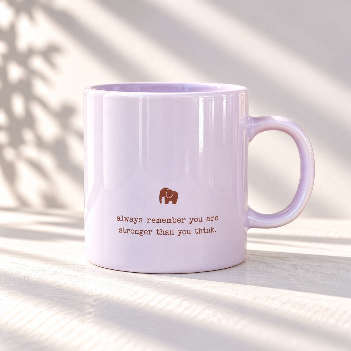 Glossy pale lilac mug with a small elephant motif above the words “always remember you are stronger than you think”