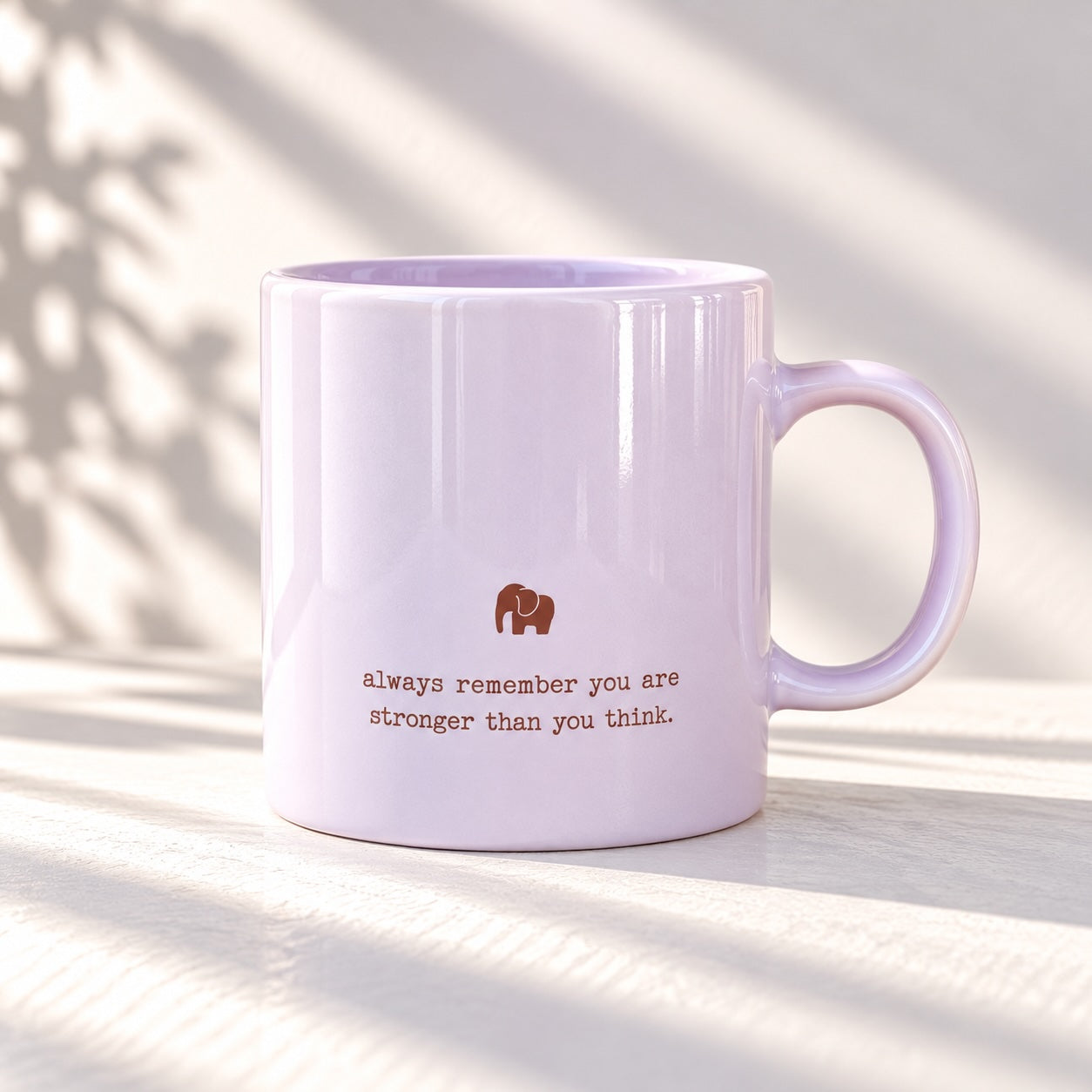 Glossy pale lilac mug with a small elephant motif above the words “always remember you are stronger than you think”
