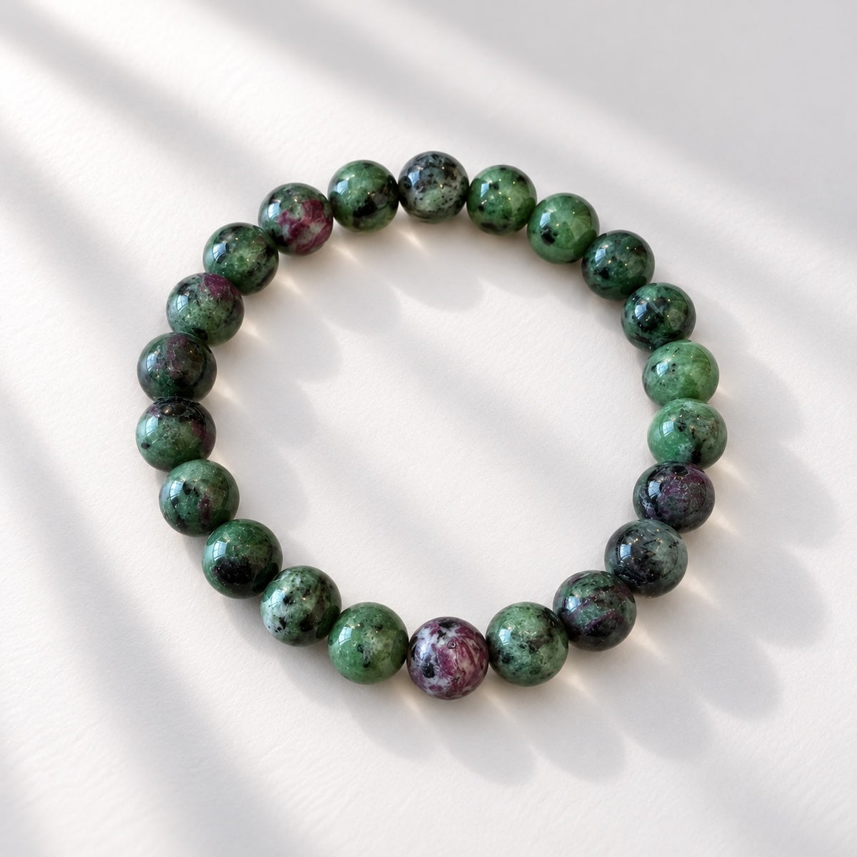 Ruby Zoisite bracelet with 8 mm round beads, typically showing green stone with ruby red and dark markings.