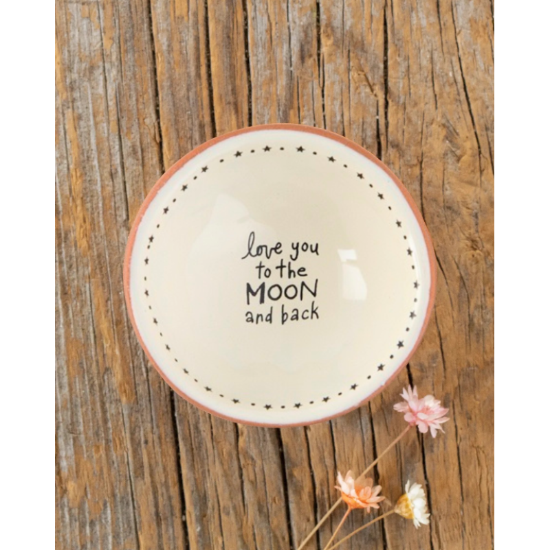 Terracotta trinket dish with text “Love you to the moon and back” on a rustic wooden background