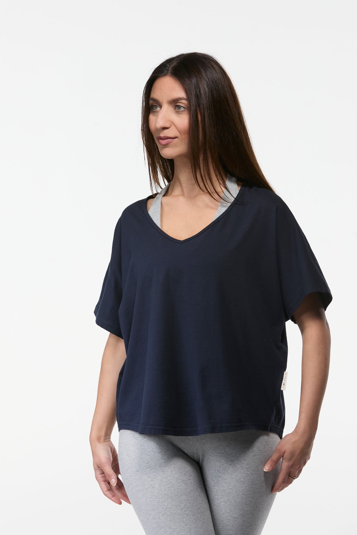 Woman wearing a navy organic cotton yoga tee with grey leggings, relaxed fit Australian made yoga top
