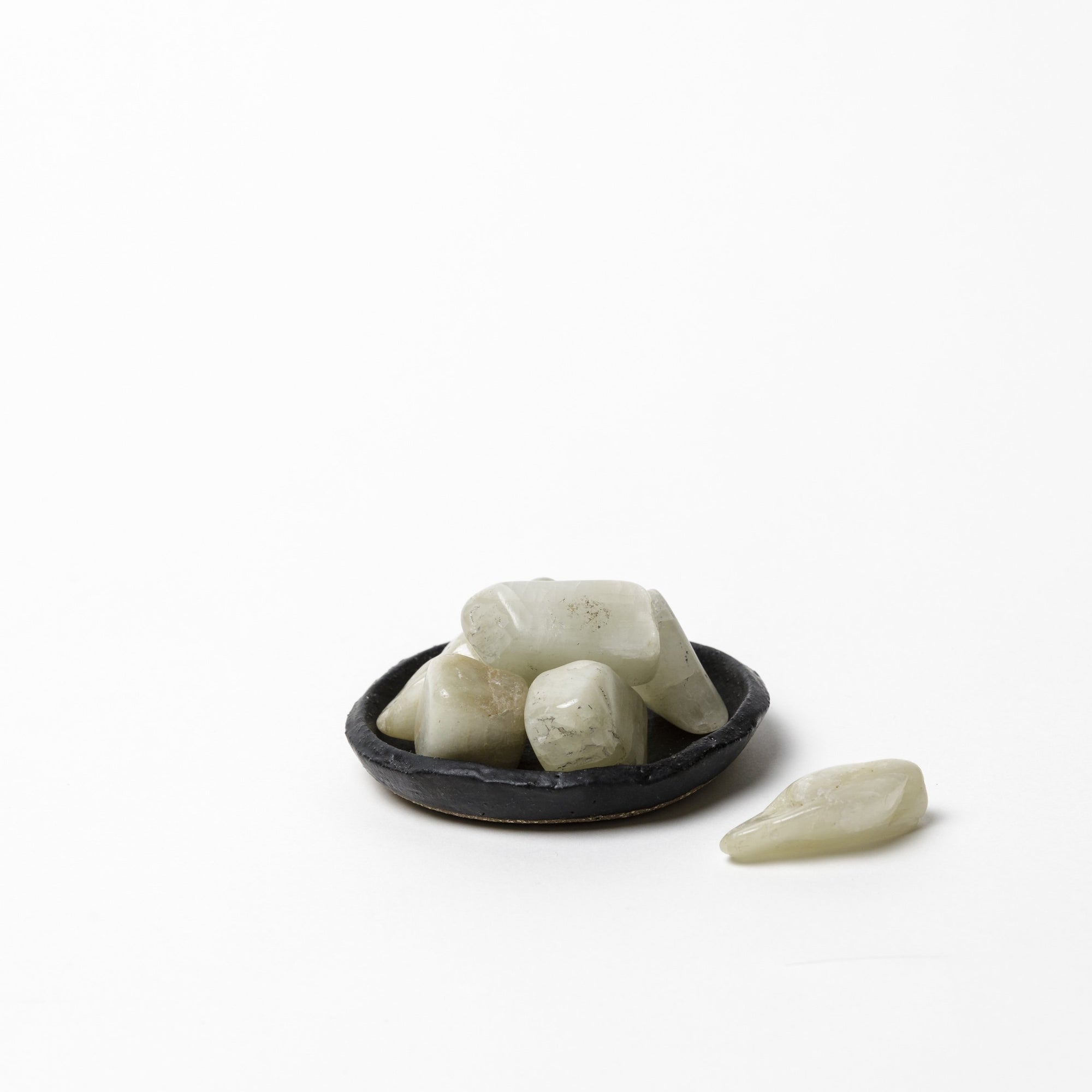 Polished Moonstone tumble stones with soft white tones and natural shimmer on white background